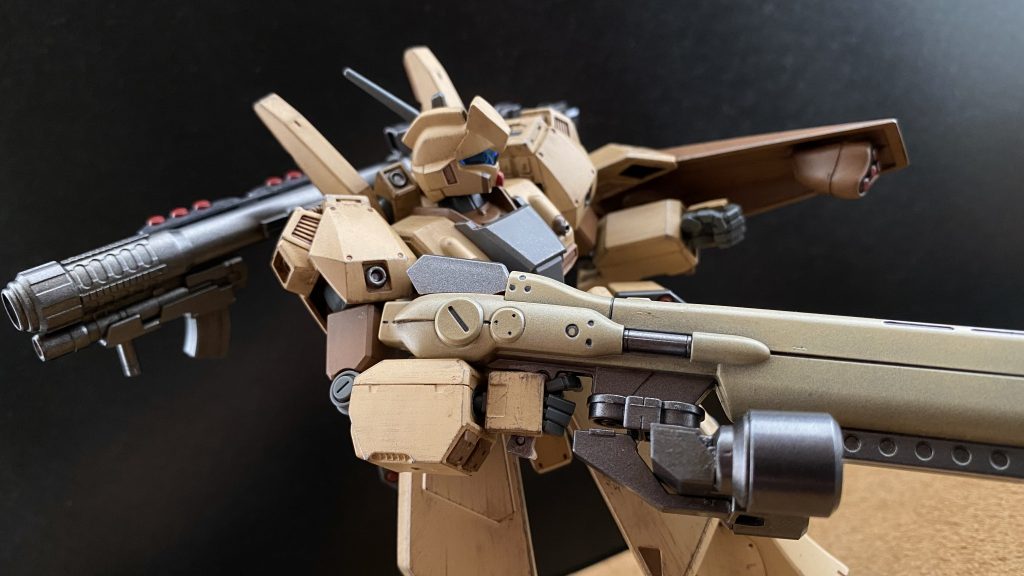 「機影を確認ッ、くそっ、大尉ッ、とんがり帽子、レッドキャップですッ」 なんてこった、単機なワケだ。とんがり帽子、レッドキャップなどと呼ばれる機体。MSN-04サザビーの量産陸戦型と言えるMSだ。ホバー機動による高い運動性能、脚部を覆うように分厚いスカート状の装甲が、その機動力を守っている。 ミサイルの着弾による粉塵の中から、その特異なシルエットが浮かぶ。「ハッ、まるでドグウだなッ」 前に暇つぶしに読んだ雑誌に載っていたニッポンの置き物を思い出す。自分達と同じサンドカラーに塗られたその機体がホバー機とは思えない初速で動き出す。速い。マシンガンの射撃音にかき消されるようにマイルズの声が聞こえる。「落ち着け、マイルズ。残念だがヤツの方が性能は上だ、単機で俺達四機をヤレると思うぐらいはな」 マイルズのマシンガン、俺のヘビィマシンガンの攻撃を、その機体サイズに対して巨大とも言えるシールドで防ぎ、時に躱しながら、同じく巨大なマシンガンが耳障りな射撃音を奏でる。ファンネルコンテナの代わりに装着された二基のバズーカが、マシンガンとは違う射線で俺とマイルズの機体を狙う。 機体も良ければ、腕も良い。あのドグウ野郎、エースだな。