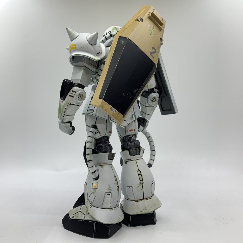 作中では、2号機を宇宙へ上げようとしているジオン軍シャトル基地を強襲したモルモット隊が、基地に放置してあったザクを鹵獲、識別コードを連邦軍の物に変え目印にシールドを背負わせ、基地を奪還しにやってきたジオン軍の迎撃に出ていました。