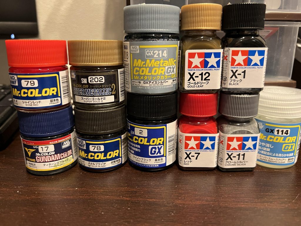 使用した塗料郡フレームはアイスシルバーがお気に入りです。メイン外装は基本機体カラー通りにチョイスしました。黄色部分は差し色にゴールドを使うと綺麗に見えるので基本赤金系を使っています。今回武器をメタルブラックで塗りましたが、艶消しを吹いたらメタリック感が全く出ずにのっぺりとした質感になってしまいました。もっと光感の強いメタリックとシルバー部分を大きめに塗り分ければ良かったと思っています。しかしHGの2パーツモナカ構造の武器って塗り分けが難しいんですよね・・・