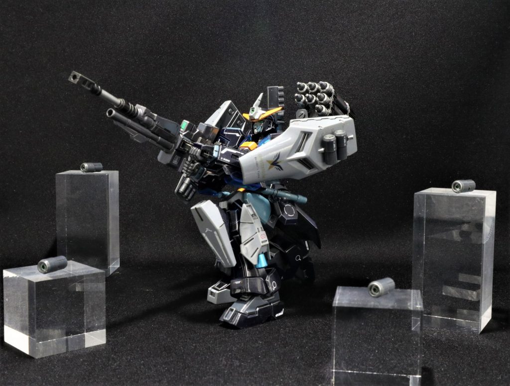 ビームスナイパーライフルを構えて。戦闘開始時にセンサードローンをフィールド上の広範囲に展開させ、3点計測で敵機の位置を正確につかみ狙撃精度を飛躍的に向上させる。