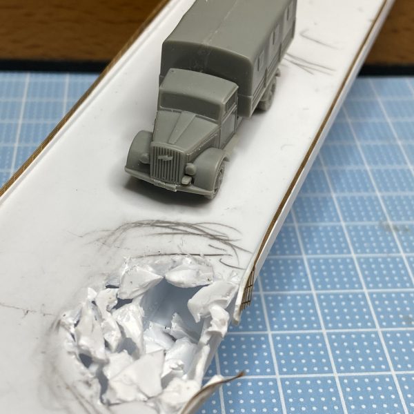 橋はプラ板の箱組です。HGと同じ1/144スケールの車両を置いてバランスをみます。少し幅のせまい普段の生活に使うような道路っぽい感じになりました。少し寂しいので、被弾後を作り橋をめぐる攻防戦があったような雰囲気にします。欄干は戦艦模型のエッチングパーツでディテールを追加しました。（2枚目）