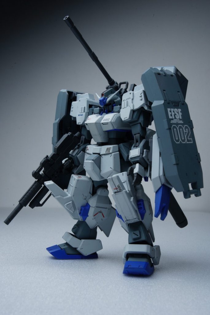 フロントビュー。見て分かる通りの重装甲化。0083年代のジムカスタムにチョバムアーマーの技術を落とし込んだのがジムキャノンⅡでありこちらはジムクゥェルにチョバムアーマと実弾兵装の追加、TR計画のデータ転用ならびにガンダムヘッドの採用でパッケージングされた機体になります。電撃ホビー誌に付属した付録パーツと他社キットからパーツを拝借して装甲を組み上げました。両肩の大型シールドから印象的には他作品に出てきそうな見た目にはなりましたがショルダーバインダーを採用したGP02を開発したアナハイムがその思想をうっすら滲み出しててもアリなのかなと思いましたので目立たせてみました。