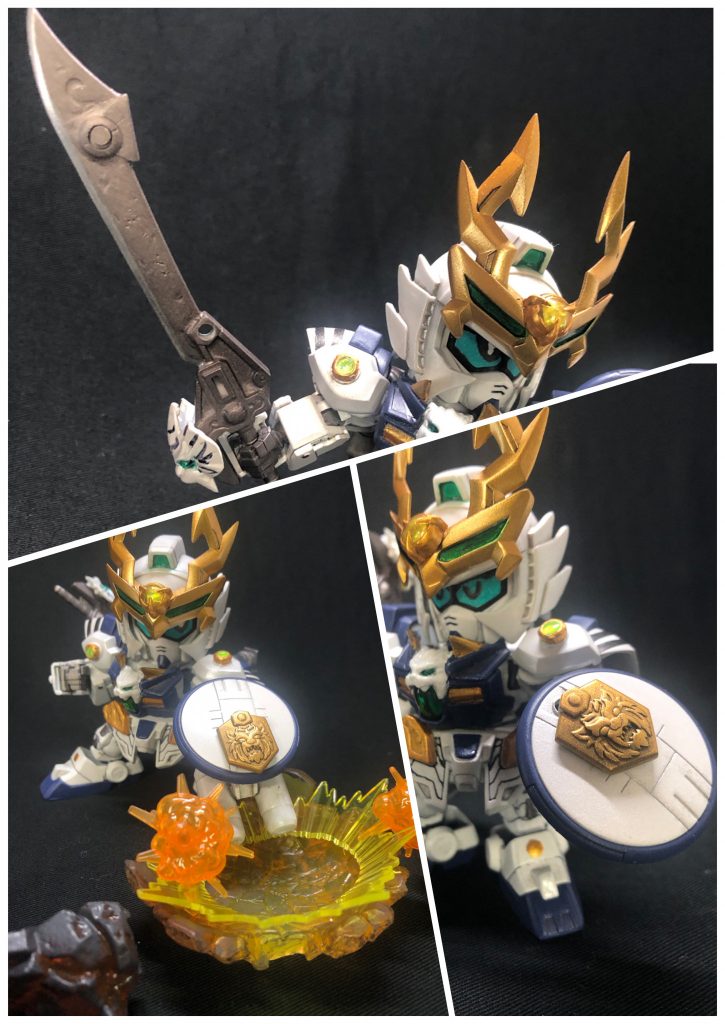 写真上武装①神器「白虎刀」ある人物が虎暁に託した身の丈程の太刀。神獣が封印された「神器」の一つで、神獣「弩虎(どうこ)」が封印されている。虎暁の扱い方は力任せに振り回すのみだったが、後に仲間達との修行を経て剣術を習得し、更なる強さを得ることとなる。写真右下武装②「虎紋の盾」虎の紋が施された円形の盾。普段は旗のように周りに見せ、その反応で恐れや敵意などを感知し、強者を見つけ出している。(元はレドームなので、探知機能の設定にしてみました。写真は目を瞑り耳をすまして探知してる感じです。)写真左下武装③爆裂盾「烈雷」背中には闘気を蓄積する性質を持つ筒を2本装備している。対多数の戦闘では、盾とこの筒を組み合わせた武装｢烈雷」を使い、蓄積された闘気を爆発させて敵をまとめて吹き飛ばす。せっかくのSDなのでBB戦士的な要素も取り入れたくて、武器を組み合わせるギミックにしてみました。モチーフ的に武器ではない部分ですが、そこはご愛嬌ということでひとつ。
