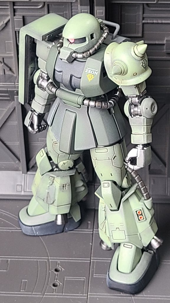 基本工作は、ボディーと頭部はHGUC040。 量産型ザクⅡのボディーをベースに胸幅を左右で2mm幅増し、股間パーツは部品取りのHGUC151 MS-06R-1Aから移植する為に加工。腕部と脚部とバックパックはジ・オリジンシリーズ003を使用。2色迷彩のグリーンは、クレオス・ガンダムカラーのMSグリーンを使用。ただいつも使用している水性トップコートが空になっていた為ストックのラッカー系の艶消しクリアを吹いてみたら、下地のメカサフ(ガンメタ)が透けて出て来て(T_T)綺麗な2色迷彩にするつもりだったのですが、使い込んで汚れた様なナチュラルエイジング処理風に(笑)まあ、これはこれで良いかな?と思いそのままにしました。