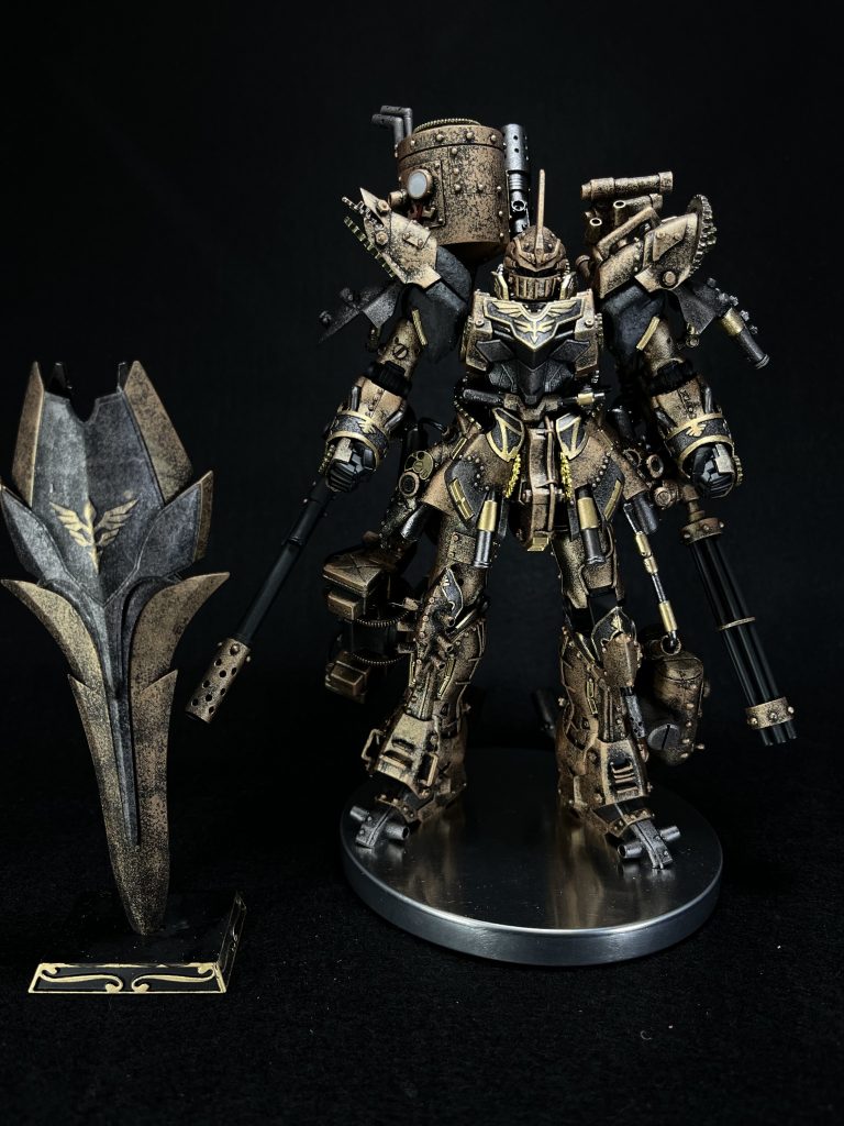 正面からスチームパンクの表現として意識したものその1、銅、真鍮、鉄などの金属表現です。全て黒サフから銅は水性タミヤカラーのダークコッパー、鉄はミスターカラーの焼鉄色をスポンジチッピングの要領でポンポンしました。銅の部分は荒めにポンポンして黒ずみを残すとスチームパンクの世界観になるかなぁとやってみました。鉄の部分は細かめにして製鉄技術がまだ甘い時代感が出ればいいなぁと思ってました。真鍮はガンマカのレッドゴールドを使用し、パイプ部分はエアブラシ、エングレービングは綿棒に塗料をつけ、慎重に塗りました。メタリック系の塗装ばかりなので塗装方法を変えることで単調にならないよう意識しました。