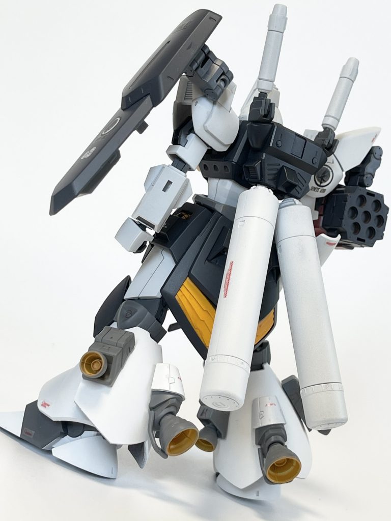 脚部はゲルググBR型や高機動型ガルバルディαなど、公式の同系高機動バリエーション機の面影を重ねる狙いで片足三発ずつ追加ブースターを付けています。リベイクに付属する脚の追加装甲がちょうど良くブースターの取り付け土台になってくれました。リアスカートはリベイクのものの上から裏面削って調整したガズのリアスカートを合体させ二重にしています。4発スラスターで更に高機動化。
