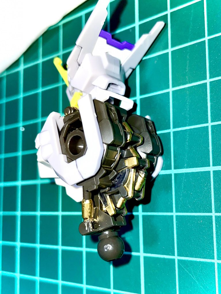 【設定】長大な鈍器を振り回すのでもなく、切れ味鋭い剣を振るうのでもない、「わざわざ前腕に水平接続した棍棒でMAを殴る」というのは非効率と言わざるを得ない。短いモーメントと旋回半径では、いかにガンダムフレームと言えど効果的な打撃は生み出し難い。 アスモデウスのコンセプトは「MAに密着するほどの極至近距離に肉迫しての破壊」。それには阿頼耶識システムを介して武道家の棍棒術をガンダムフレームに再現させる必要があった。「いち個人の武術のデータ化」ひいては「武術データをコピーして量産する」というMSの強化プランでもある。武道家とガンダムフレーム両者の距離を縮めるために、アスモデウスのフレームには大幅な改造が施された。腰から前腕へ効率良く動きを連動させるため、椎間板ダンパーや腹斜筋シリンダーなどが増設された。「肩の回転で殴るのではなく、腰の捻りで殴るのだ」とは当該武道家の言。 ──ところが、完成と同時に戦局は宇宙へと移り、間合いが広がってしまったために急遽ジャベリンとライフルを持たされて宙へと上げられてしまった。そして程なく終戦し、アスモデウスは出番無く役目を終えた──