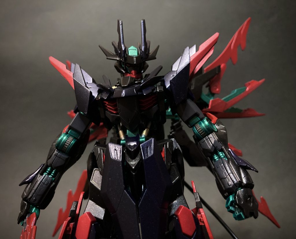 顔が見えづらくなっていますが、緑のフレームにダークグレーのフェイス、カメラアイは蛍光ピンクです。また、フロントスカートはアリオスガンダムのもので、前掛けのように合わさってますが、稼働に合わせて左右が独立して動きます。