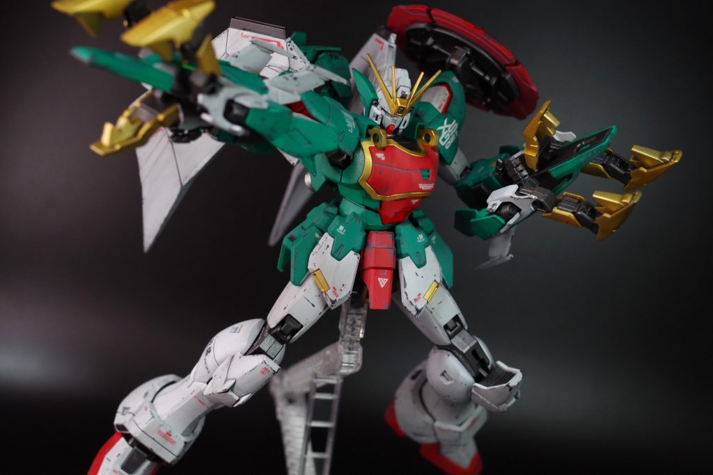 まず両腕にドラゴンハングを装備するため、両腕のフレームを右腕にして、そのままドラゴンハングを装着してます。接続アームが外側に回ってないのでよく見たら変な感じですが、遠目かつ薄目で見たら気にならないのでそのままで。肩のシールドはドラゴンハングと背中の羽根とめちゃくちゃ干渉しちゃうので、パワードジムカーディガンについてたアーム基部を使って3軸くらいで可動するようにしました。おかげでポージングで逃がせるようになりました。