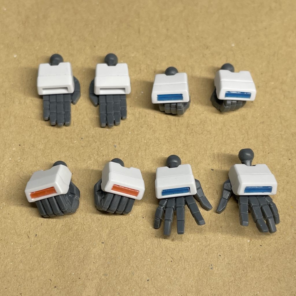 手甲の加工 キットのクリアブルーとクリアオレンジのランナータグを加工して、手甲パーツに接着し、取り付けた部分とツライチになるまで削りました。 手甲パーツは、武器持ち手の手甲にクリアブルーのランナータグを組み込み、それ以外の手甲パーツは左右とも共通で同じ形状なので、無加工、クリアブルーランナータグ組み込み、クリアオレンジランナータグ組み込み のものを二つづつ作りました。