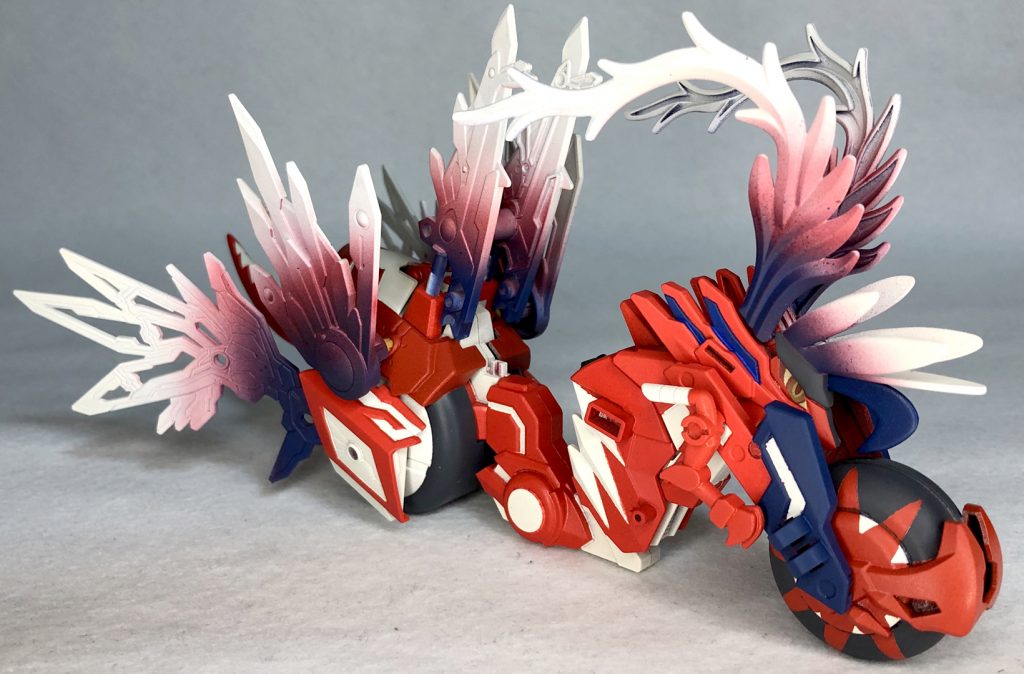 正面「トリニティバイク 赤兎馬」をベースに制作元の姿より羽根パーツを大量に増加頭からも羽根を生やし見た目を近づけました。元の姿はバイクではないのですがタイヤを思わせる部分など乗り物を思わせる雰囲気があるのでこのような形で制作してみました！【追記】めっちゃバイクでしたねw