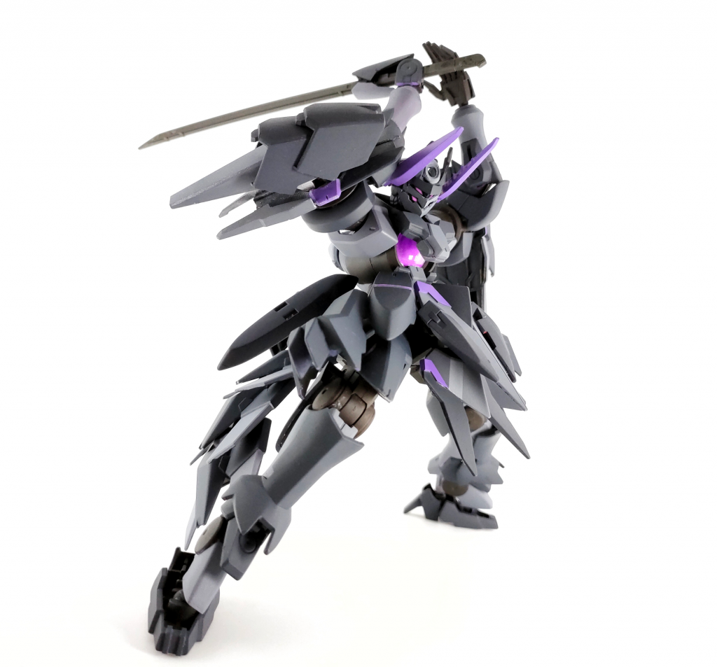両肩に装備された大型のGNコンデンサー兼バーニアで、重装甲ながらも高い機動性を有しています。防御用の実体シールドなどはありませんが、肩のGNコンデンサーからGNフィールドを流線状に展開することで、攻撃を防御するのではなく、受け流し、いなすことでダメージを軽減します。攻撃をされていても留まるのではなく接近するための設計になっており、防御する暇があったら攻めろ!がこの機体の運用方針です。