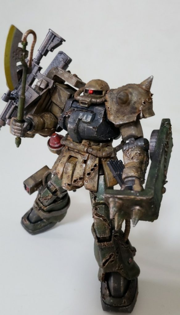 設定としてはキンバライト基地の11機目のMS、ただし損傷が酷すぎるのでパーツ取り用に格納庫の隅に置いておいた機体。それを今回のHLV打ち上げ作戦のために中身だけ最低限の修理をして頭数を増やすために強行出撃させたMS。なので銃火器も有り合わせ。最後の出撃なので使える武器は全部使うって感じですね！最初はシールドとミサイルポッドは他機の新品装着って設定でダメージ加工なしだったけど、そこだけ浮いちゃうので結局ダメージいれました😅