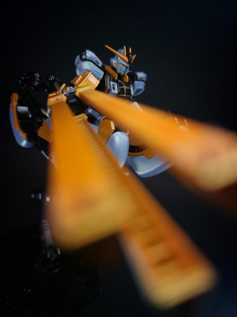 武装・必殺攻撃レールガンアトラスガンダム専用の試作レールガン。機体の全高に匹敵するサイズの大型火器だが、本機のパワーであれば片手で軽々と扱うことが可能。火薬を用いる一般的な実体弾火器よりも遥かに高速度の初速を得られる点が特徴で、3本の給電レールによる電磁誘導で実体弾を加速・発射する。その威力は長距離から重装甲のMSを一撃で撃破する程。水中ではレールガンとして使用することはできないが、放電を利用した電磁パルス・ガードとして応用することが可能。ミサイルや魚雷程度であれば完全に無効化可能だが、戦艦の主砲やメガ粒子砲は防ぐことができない。