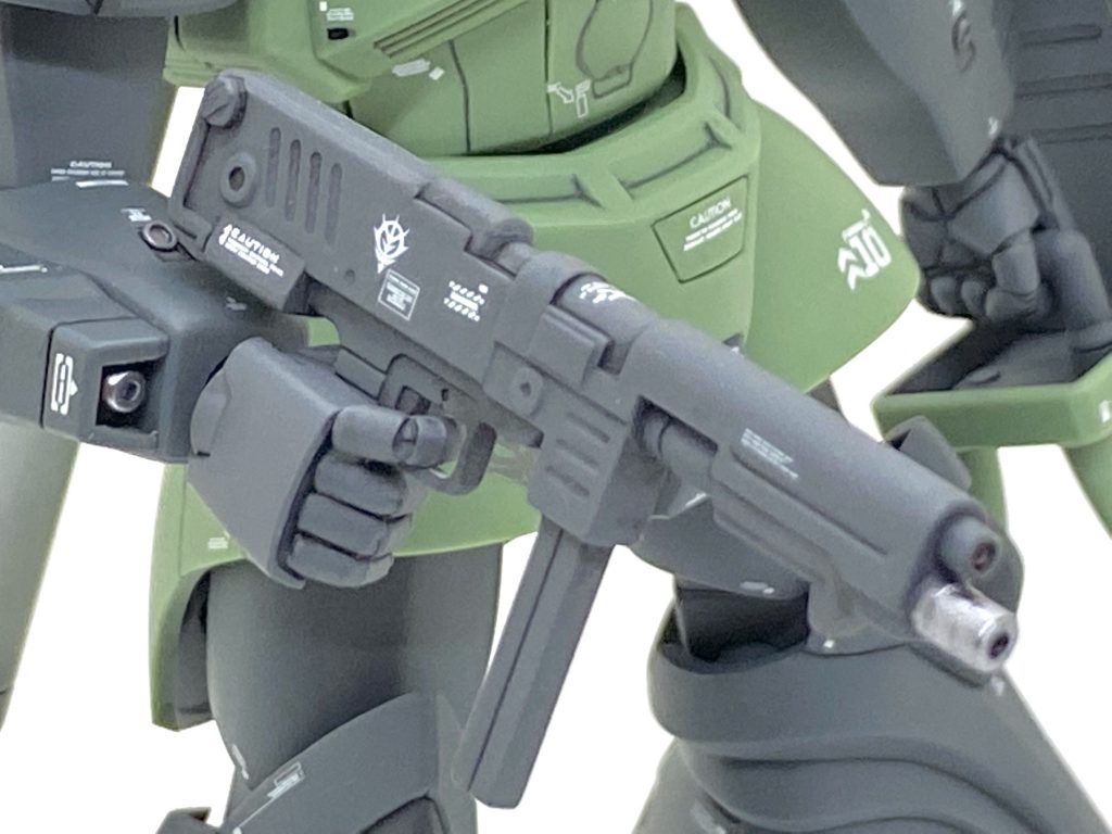 当初はガトー専用に付いていた試作ビームライフルでも持たせようとも思いましたがグリップのサイズが合わず断念しました。実弾系の武器はマズルをメタリックにはしないのですが・・・持ち手を付ける所が無かったのでメタリック箇所をマスキングテープで巻いた後に持ち手で挟み、塗装やつや消し吹きをしました。