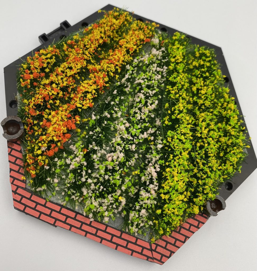 ベース。アクションベースを軸に、ジオラマ用の花を植えて、ボールデン仕込み。レンガシールはseriaのものを使いました。