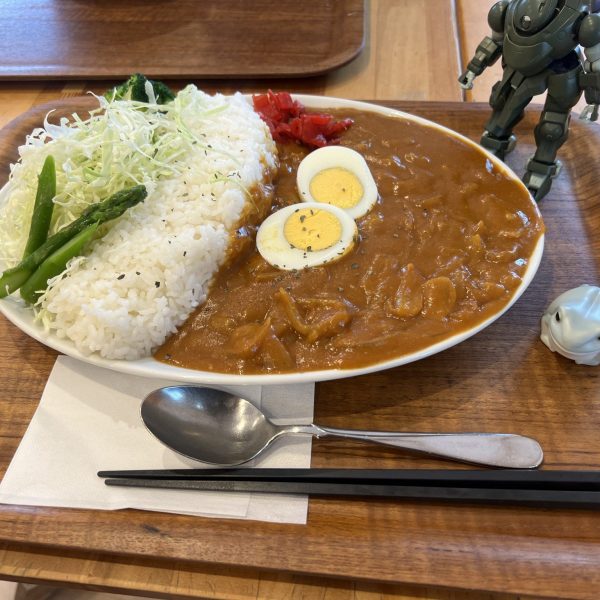 第一話「激闘❗️(ガン)ダムカレー」皆さんはカレーと言う食べ物をご存知ですか❓インド人が1日3食、食べていると言う伝説の食べ物。数種類のスパイスを掛け合わせたスープ状の物をパンらしき物やライスなどと一緒に食すととても美味しい。この物語はそんなカレーに勇敢に立ち向かった男の戦いの記録である。さあ皆さん❗️ガンダムファイトレディ〜ゴー‼️僕はまだ迷っていた。券売機にダムカレーと書かれたボタンがあった。ダムカレー、んダムカレー、がんダムカレー、ガンダムカレー‼️心の中で指をパチン。こいガンダアアム‼️コアランダーに乗ってテーブルまでゴー❗️しばらく(がん)ダムカレーを心まちにしていると、ついに「食券番号2番でお待ちの(がん)ダムカレーでお待ちのお客様〜」テーブルの上には僕の想像を超えた特盛のカレーが圧倒的な存在感で立ちはだかっていた。その時初めてダムの意味を知った。大量カレーのルーを大量のご飯でせきとめて、その風貌はまさに「ダム」であった。心の中のゴングが鳴り響いた❗️一心不乱にカレーとご飯にくらいついた。半分くらい食べたところでピンチが❗️お腹がいっぱいになりはじめた。僕はここで頭脳をフル回転させた。そうだ‼️嫁さんにちょっと食べさせれば良いんだ。名案だと思った。好都合に嫁さんの好きな卵が乗っている。これを食べてもらえば…。「玉子たべる❓」聞いてみた。「いらない」「美味しいよ〜」くらいついてみた。すると静かに箸が近づいて来た‼️僕は勝利を確信した❗️すると玉子の黄身だけ食べて「おいしい」えっちょっ「ブロッコリー食べる❓」「いらない」終わった。しかし僕の中のドモンはもう一度立ち上がって叫ぶ❗️「俺のこの手が真っ赤に燃える❗️お前を倒せと轟き叫ぶ❗️」「シャーイニング❗️フィンガーーー‼️」完食😁👍あとがき鳥取県日南町の道の駅にての出来事でした日南町は「福」の文字が付く地名が多いので訪れた人に福をもたらすとか。自然も豊かで山に囲まれた静かな所です。トマトが名産らしくダムカレーにも使われていてとても美味しかったです。愛らしいマスコット「オッサンショウウオ」はなんか可愛いかったので写真を撮っておきました。 （1枚目）