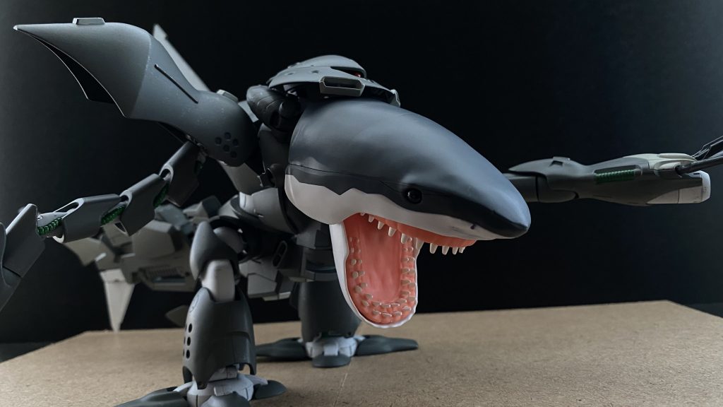 　翌日、別任務で基地を離れていた専属パイロットの少尉が帰還した為、評価試験を開始する。初め、我々の不安をよそに思いがけずスムーズに進む評価試験だったが、評価試験を行うポイントを変更する為の移動の最中にそれは起きた。　「一体、何が起きている！」　鳴り響くアラート、パニックになったパイロットの声が聞こえる。機体の制御が効かないのだ。「これはっ、暴走警報っ」　パイロットの手を離れたその機体は、その進路をビーチへ向け、そして、ロックオン。一体何を。特務大尉が、モニターを切り替えコクピット内モニターに変える。そこに映し出されたのは。人。人だ、ビーチでビーチバレーを遊ぶ大学生陽キャ男女グループだ。海へ飛んでいったボールを、俺がとってきてやるよ。と、泳ぎ出すいかにもアメフトをやっていそうな男(マッチョ)が、機体の制御を失ったシャークゴッグに…。　その後も、ビーチの人影のない所でイチャイチャしているカップルや、高級クルーザーの上で盛り上がっているセレブ男女グループが、次々と襲われていく。　そんな時、センサーに反応がある。MS反応。パイロットの少尉に呼びかける。「少尉っ、MS反応ですっ。機体照合、こ、これは、RX-78、…ガンダム、です」