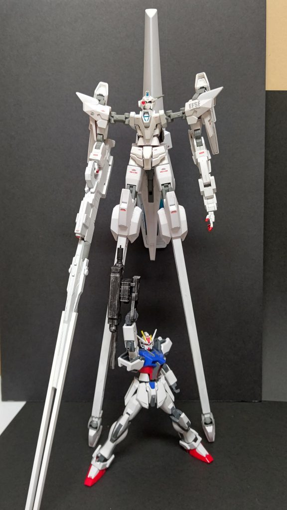 フロントショット「MGFAガンダム(サンダーボルト)とかに付いてくるスタンドのアレ」を脚部に流用しており壁に寄りかかることでギリギリ立てます。同スケールのEGストライク(とっつき装備)と比較すると長さが際立ちますね。体型の全体的なバランスを整えるために肩関節にフレームアームズの膝関節を、左腕にジョーハウンドの腕を接続し、背部推進機関は1/100キマリストルーパーのデストロイヤーランスを使っています。