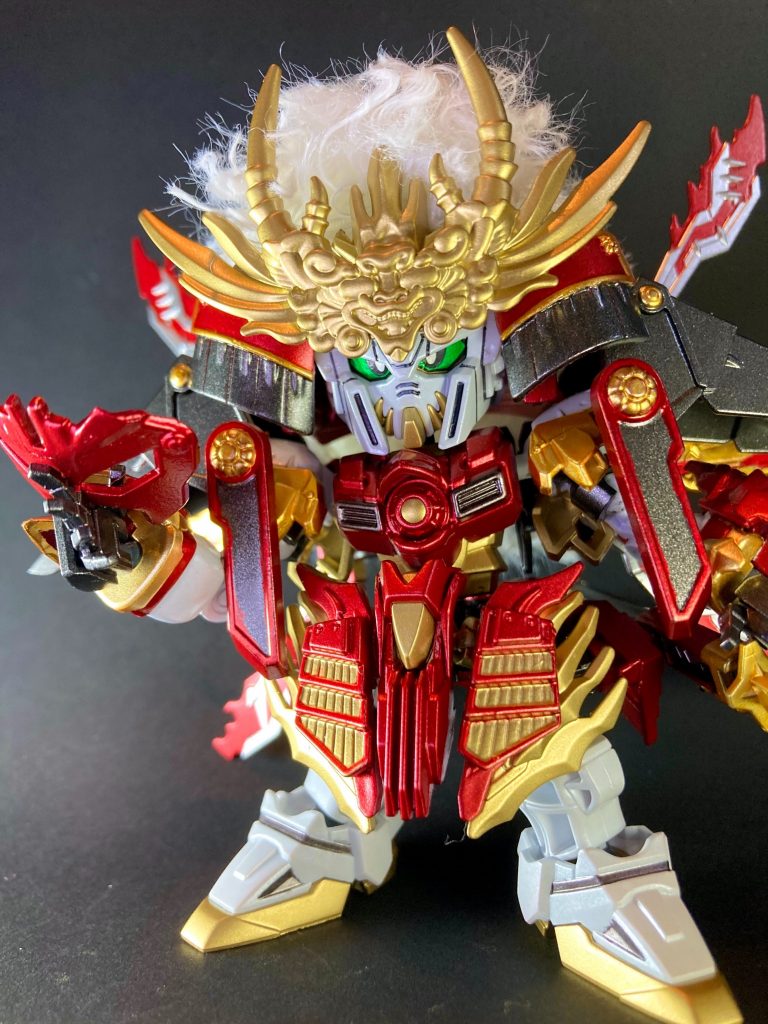  〜〜〜〜〜〜〜〜〜〜〜〜SDWヒーローズ・オリジナル英傑を製作しました。前回製作した謙信マスターガンダムとのライバル関係を意識して、武田信玄を演者:ゴッドガンダムでアレンジしています。造型は三国創傑伝・炎皇張飛ゴッドガンダムをベースキットに、SD戦国伝 武神降臨編の武田信玄頑駄無より特徴的な意匠パーツを随所に仕込む形で戦国武将らしさを取り入れました。武田信玄の象徴的伝来甲冑の諏訪法性兜をイメージして、手芸用のモコモコ白毛をふんだんに爆盛りし、形を整えてハサミで切り揃えてケープで固めています。