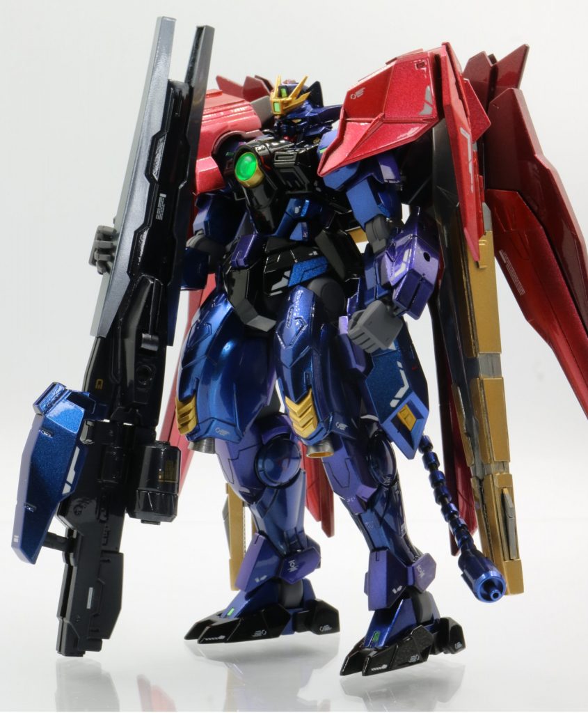 巨大なライフルを支えた立ちポーズ。一度やってみたかった！ハンドパーツはビルドナックルに変更し、武器を支える右手は、平手タイプの指先を切り貼りして武器を支えている風に変更しています。左手も握りこぶしタイプを使用することでキット付属のものより引き締まったイメージを目指しました。腰から生えている尻尾はサザビーのファンネルを加工したもので、「テールビームガン」という設定で、先端からビームが出ます。しっぽビーム！！