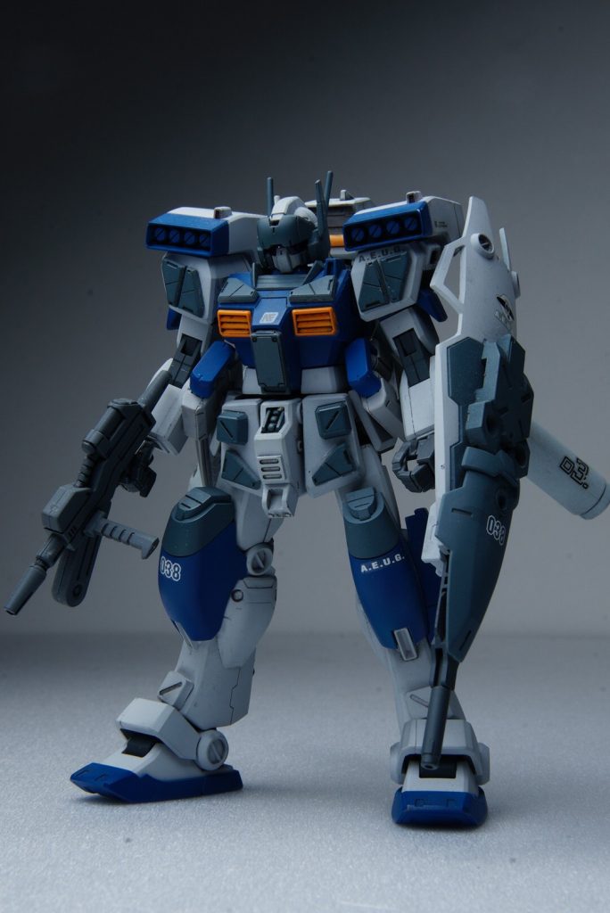 フロントビュー。各部に追加装甲とプロペラントタンクを追加して対被弾耐性の向上と推力確保の為のプロペラントタンクを各部に増設したり等の改修と武装に関しても試作型の速射性に優れるシールドと一体型のチェーンガンを装備しています。対空迎撃に特化させるために実弾による弾幕を展開できる様な兵装になりますが機関部と弾薬をジムライフルより流用しているのでケースレス弾にすることにより廃莢による地上への二次被害を出さない配慮も行われています。また頭部には追加で複合センサーからなるバイザーユニットを装備しています。