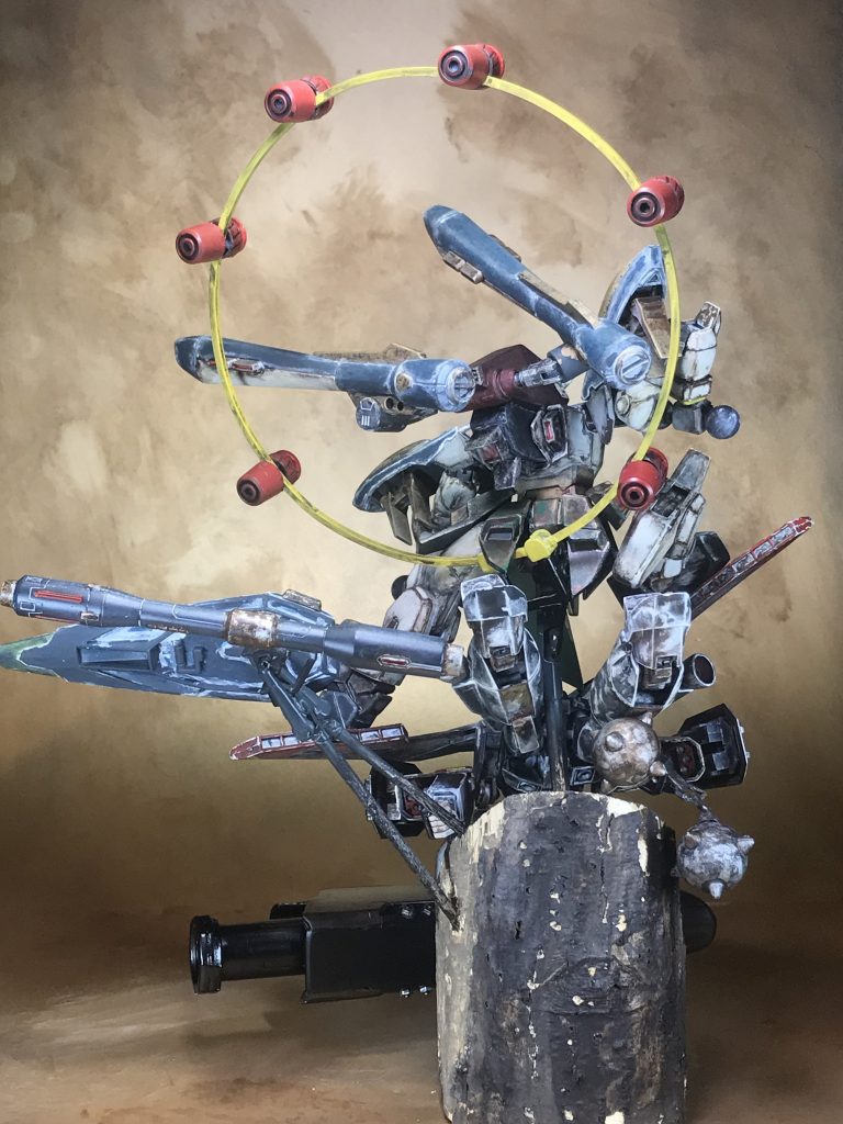 後側台座は前回のカブトムシのとまり木の残りの半を使用しています。本体と武器は今回も持ち手です。黄色い輪は角プラ棒をロウソクで温めて丸めています。赤い太鼓はMG Ex-Sの頭部と膝のインコムからかき集めています。