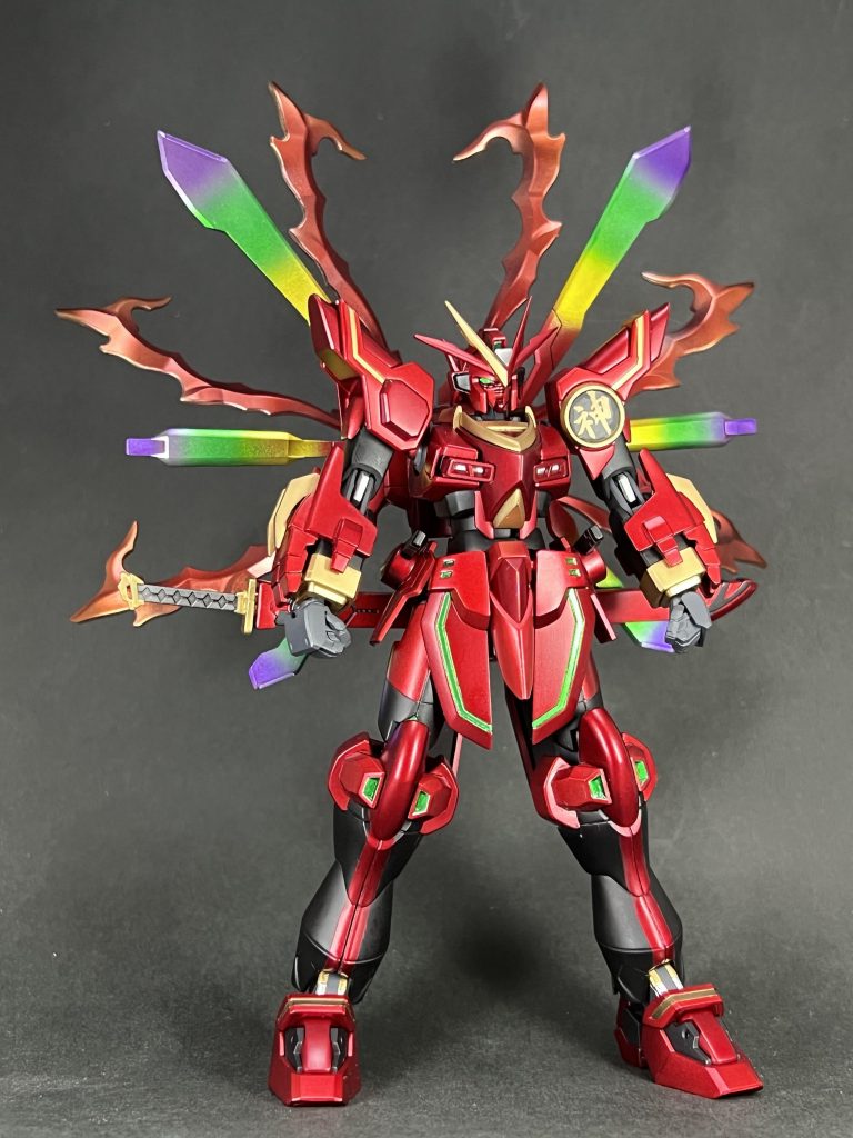 全身写真。カミキバーニングガンダムをベースに、腕部と腰、バックパックのコアランダーをゴッドガンダムのものにしてます。腰部刀にはガーベラストレートを使いました。今回力を入れたのがグラデーション塗装。炎エフェクトはクリアイエローとレッド、背部スタビライザーには孔雀をイメージしてクリアレッド・イエロー・グリーン・バイオレットで塗りました。やった事ない表現だったので、塗ってて楽しかったです。