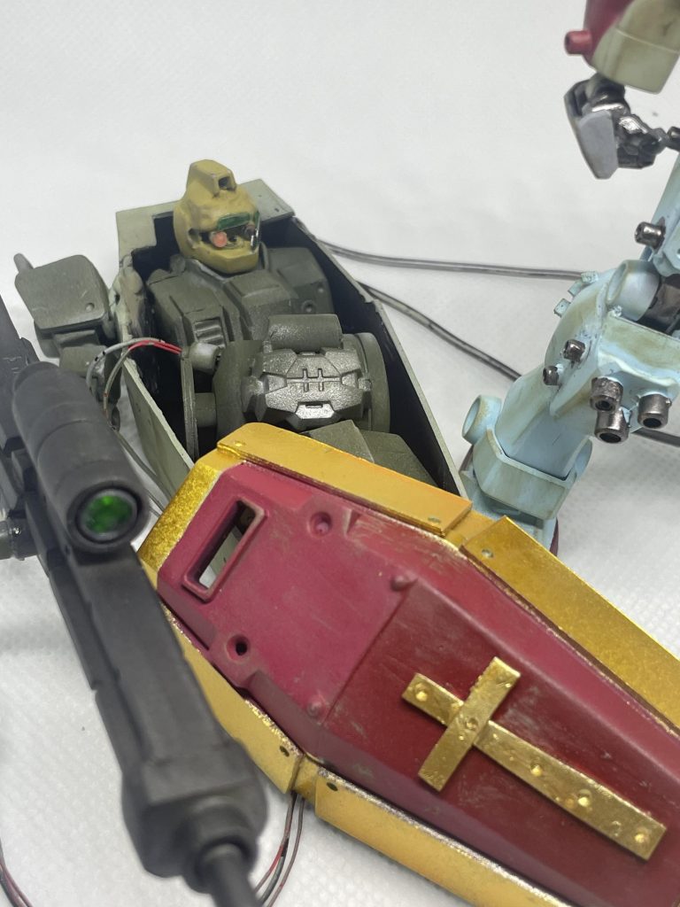 棺(?)の中には大破した陸戦型Gの上半身とジェネレーターが収納されていて、これはロングビームライフルのエネルギー源となっている。遠隔操作で棺の右腕は操作可能で2方向からの攻撃が可能である。