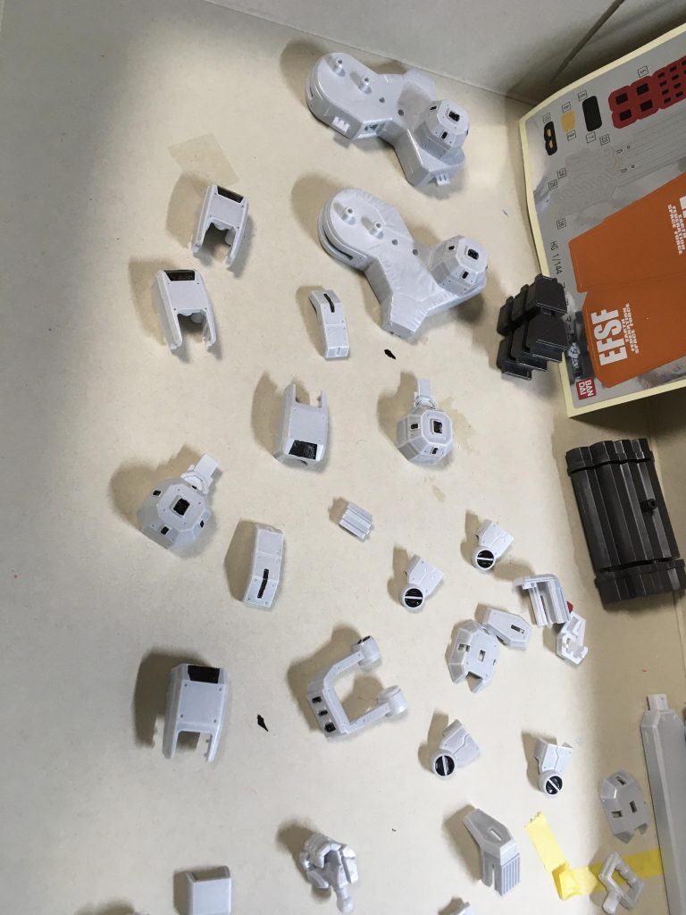 部分塗装が細か〜い。バーニア塗らないといけないのね💦右上にシールがあるじゃないか・・ 使えよ〜。早く使え・・ だが断るバーニアの噴射口の赤はメタリックにしたいんだ・・。 盾もオレンジシールがあるじゃないか・ 使えよ。早く使え・・