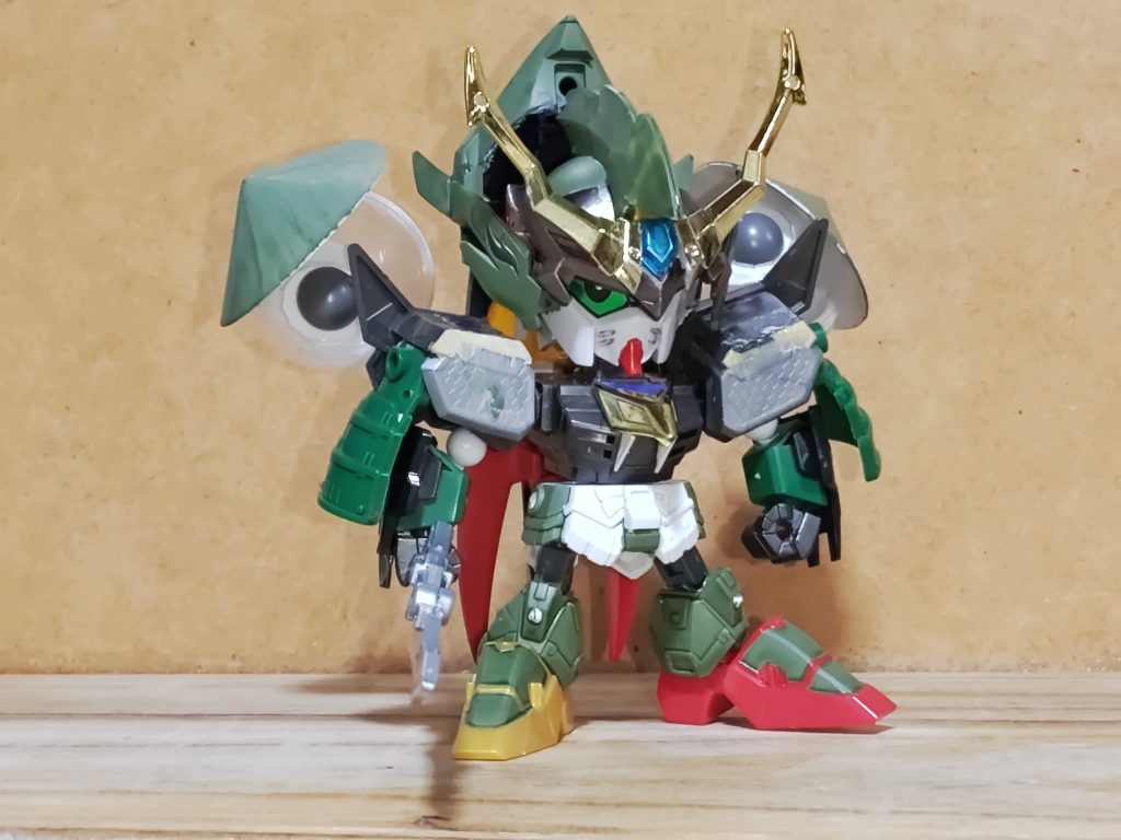 カオスガンダムをメインに、NT専用ジムジャグラー、ウィンダム(というかネオ・ロアノーク)の要素を取り入れた、トリプル(見方によってはカルテット)モチーフのオリジナル武者です。この様な形になったのは、内容上完全にカオスの形状を完全再現しようとすると、バックパック部分にモチーフ元のパーツを使う事態になってしまい、元々のコンセプトに反してしまう(新鋭のページを参照)のと、『武者烈伝』に登場する自無助のイメージを入れたかった為です…そっち系ではないですけどね。パーツ構成(露阿納駆形態も併せて)は、頭:張飛メイン。兜は猛虎装ベースにプラ板を貼り、于禁の兜のパーツ、角飾りは砕牙の物を分割した物を猛虎装のクリアパーツに直付け(!)。あと猛虎装の兜の面部分はモールドを入れてネオのマスクに見えるように加工。胴体:孫権ベースに真星勢多(ジャンク)、プラ板。側面には磁石を貼り付けて、雷装張飛の鎧を加工した物を装着出来るように加工。腕:孫権辺りの肩に関羽の腕、夏候兄弟の腕アーマー、肩は公孫瓚イージーエイトベースに楽進、関羽とボールデン。モールドはプラ板でスクラッチ。腰:孫権ベースに雷装張飛。側面には露阿納駆の兜パーツ兼用で夏候惇の兜パーツを、つま先はBB戦士イージス直付け。大駈麗:猛虎装を基部に天翔狩人や刀留義守、陸遜、武者ウイングゼロ、賈詡、切り取った猛虎装兜パーツの組み合わせ。後述の暴留の接続は夏候兄弟の腕を使用。武器:孫権の物をモールドを掘り直し。暴留二体:東急ハンズで買ったカプセルをベースにプラ材や市販パーツを組み合わせたフルスクラッチ。ジムジャグラーの意匠を入れることにした時、コイツらが特に難儀しました。駕留駄:ストライク劉備の武装パーツにアムアムだけででっち上げ。脚部はSMK-Vフレームで膝可動、腕は市販パーツで肘可動を実現、首の可動もSMKフレームを参考に拡大しています。そしてこれの恩恵で、諦めていたMA形態への変形が出来るようになりました…マジ感謝。尚、ウィンダム(及びネオ)の意匠を入れたのは、ゲーム『GENERATION of C.E.』でネオがカオスガンダムに搭乗するエピソードがあったためです。因みに私は攻略本を立ち読みしたのみで未プレイです。そして彼の性格はスティングとネオ(つかムウ)を足して2で割ってます。新鋭の亜駆威羅装のモチーフはソードインパルスとカオスインパルスです…相変わらず色はフォースインパルスのまんまですがね。