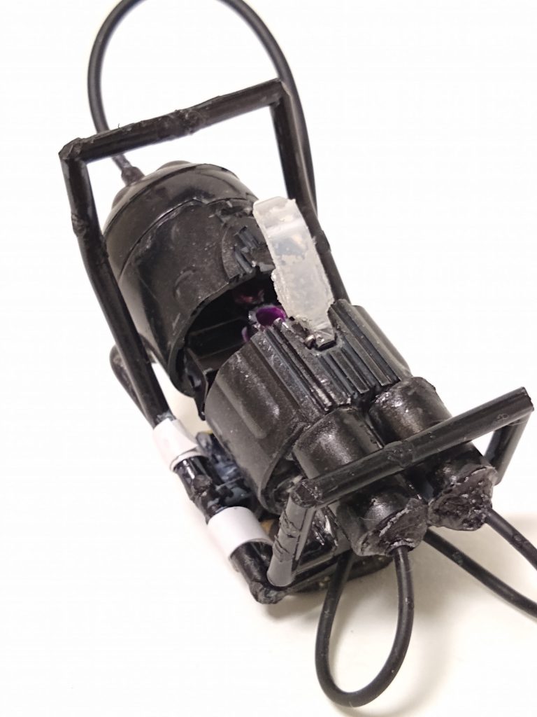 背負子とカートリッジ他恐らくガンタンク初期型の物と思しき排煙ダクトを輪切りにして、タンク部分に。中をくり抜き、プチッガイ用の繋ぎ手を削って蓋をし、その先に壊れたイヤホンのコードを接着しました。タンク下部の管は輪切りバズーカとイヤホンコードで再現。タンクを囲むフレームはランナーを曲げて作成しました。径の違う真鍮パイプ製のシリンダーと、プラ板と針金で作った留め金のおかげで、タンクの開閉ギミックもある程度再現できました。カートリッジはバズーカのマガジンを半分に切り、ポリキャップを接着して作成しました。タンク内にきっちり5個収まります。なお、ズゴックたちの腕や脚とショットランサーを繋げた尻尾、余っていた手を組合わせて磁石を仕込み、胸部に張り付けた白笛の写真は、スペースの都合上割愛します。