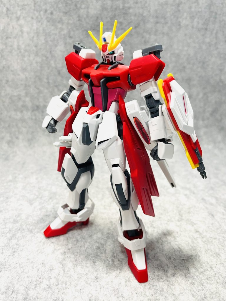 ビルドストライクCルージュ素の状態フロント。Cは「カスタム」あるいは「カガリ」のC。肩はスターバーニングのクリアパーツを外してアームアームズのジョイントを組み合わせ。サイドアーマーにはイージスナイトのサイドバインダーと、ユニバースブースターのスタービームキャノンを装備。また、右バインダーにはビームサーベル2基をマウント。足部はウイングゼロ炎から。