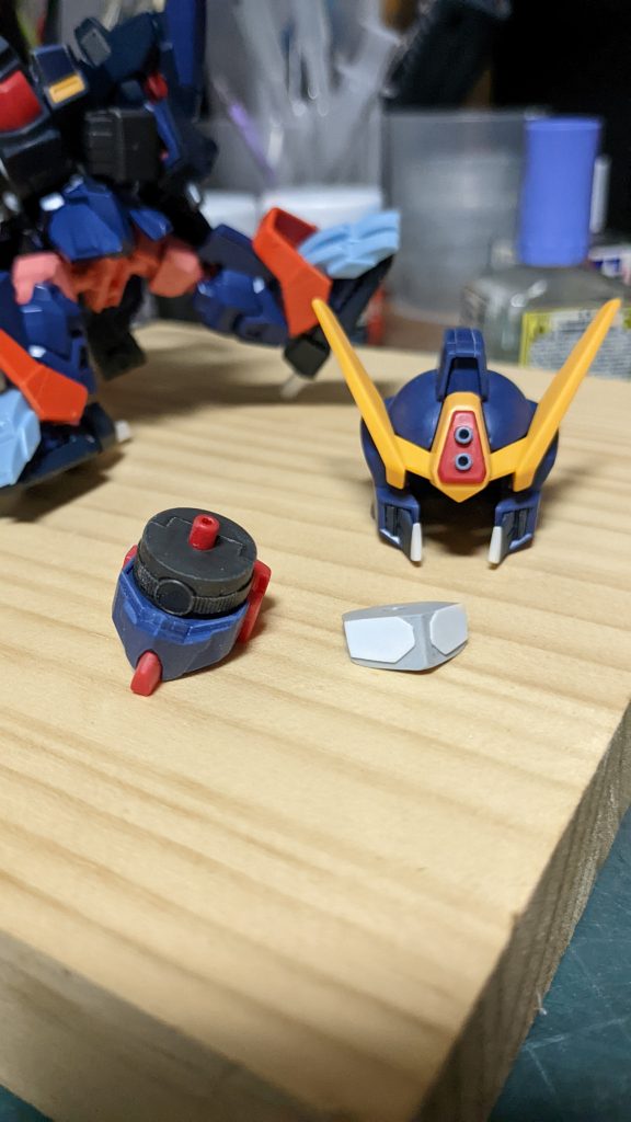 ツインアイの制作と頭部の装飾。プラバンでツインアイを制作、元のモノアイに被せて取り付けます。額にコマンドガンダムっぽく筒を二本埋め込んでいます。あと牙っぽい装飾も追加。