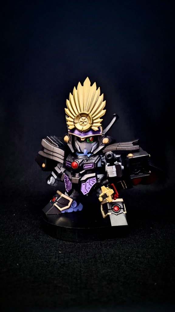塗装はアクリジョンをメインに使用。ブラック、ゴールド、明灰色、すみれ色、モンザレッド、メタリックレッド(アクリジョン)メタリックパープルはアクリジョンのシルバー、メタリックレッド、メタリックブルーで調色。シルバーを入れることで明るめのメタリックパープルが完成します。前立はタミヤのゴールドリーフで、刀はMr.カラーのシャインシルバーで塗装しました。