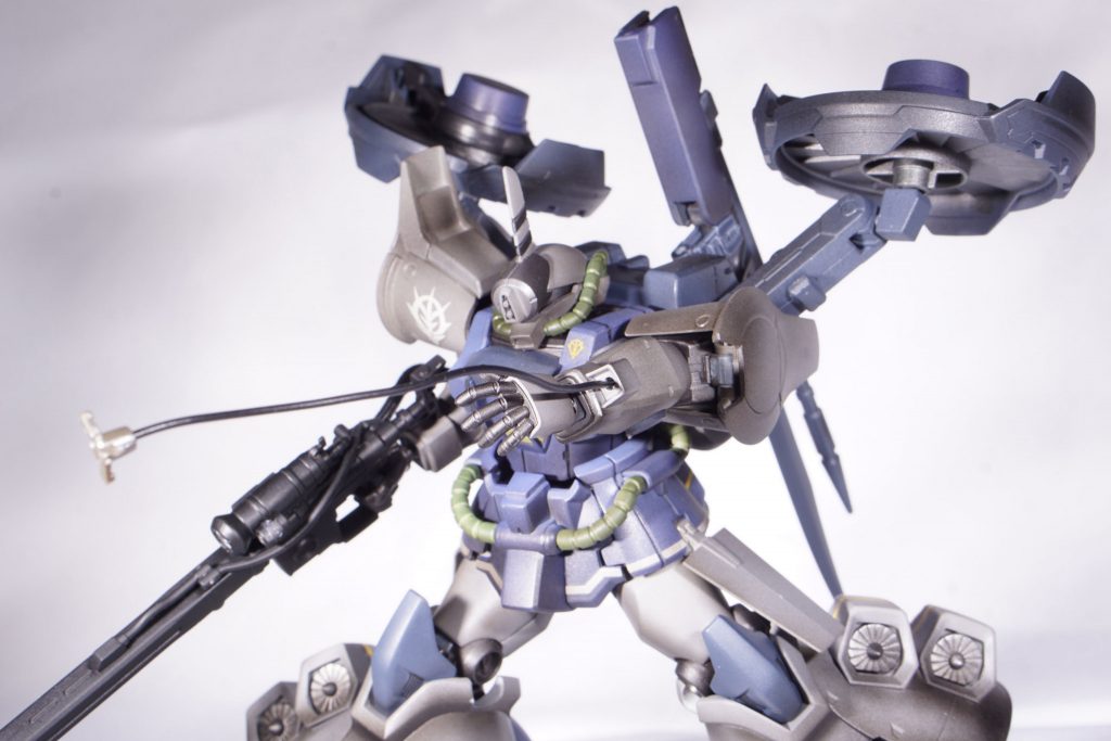 サブ武器「ヒートロッド」本来のグフ型機体のヒートロッドは右手に装備しているが、子の機体ではライフルの運用の兼ね合いで左手に装備。都市部での戦闘の際にビルなどの建物に引っ掛けて軌道を変える動きをするなどにも活用する。