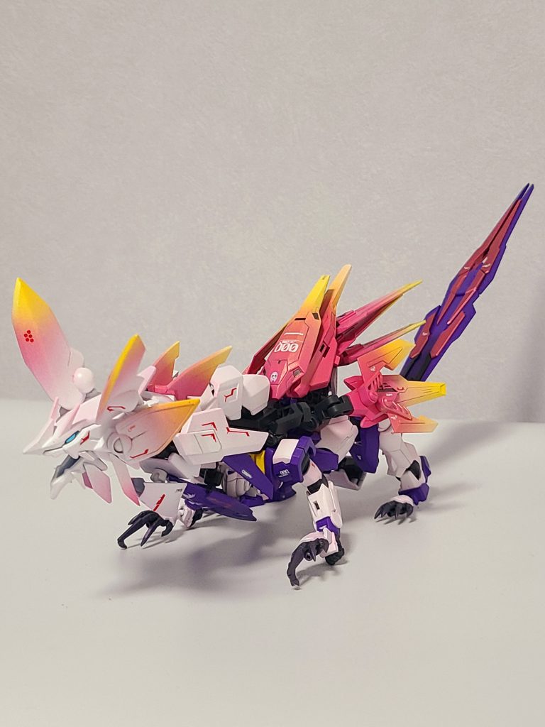 塗装レシピガイアカラーとクレオスのミスターカラーです。・ホワイト部・・アルティメットホワイト・ピンク部・・・マイザーピンク・武器等メタリック部分・・GXメタルピーチ(クレオス)・黄色部・・・・MSイエロー(クレオス)・紫部・・・・・パープル(クレオス)・間接部・・・・ネイビーブルー(クレオス)写真ではうまく写っていないのですが、クレオスのクリスタルカラー(トルマリングリーン、トパーズゴールド、アメジストパープル)で表面をオーバーコートしているので、光が当たる部分は色調が少し変化しています。