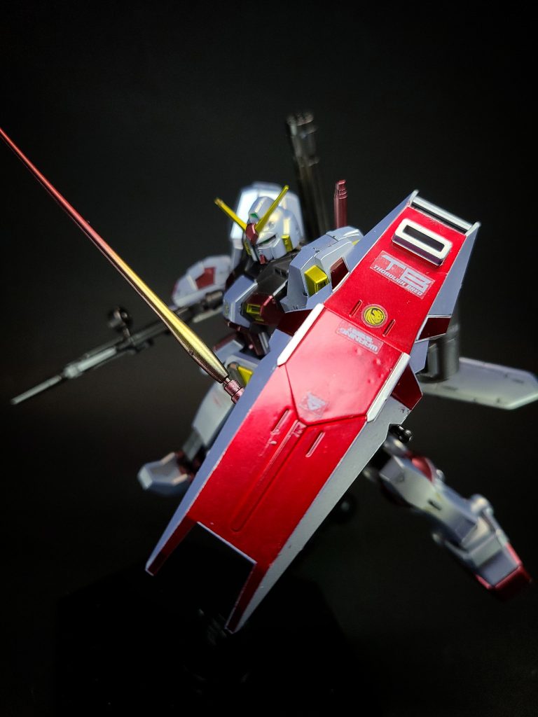 ビーム・サーベルバックパックに2基装備している。シールド伸縮機能付きのシールド。格闘武器としても使用可能。