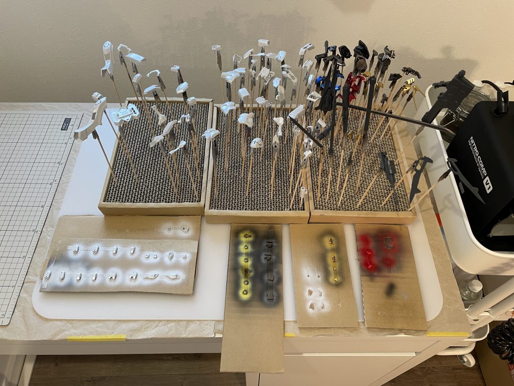 メインの塗装終了時の写真です。白パーツと青パーツを『パール』、赤パーツを『キャンディ』、黒パーツと黄パーツを『メタリック』で塗装して、墨入れ・デカール用に光沢クリアでコートしました。武装はメカサフに光沢クリアを吹いたのですが、これはイマイチでした…