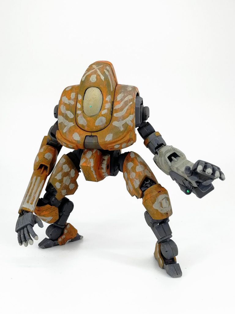 左腕の下腕だけ別の色にしてニコイチ感を出していますが実はオレンジ部分も彩度をわずかに変えて少なくともガワは実はサンコイチという機体にしています。左腕に取り付けられた武装は歩兵携行用のアサルトライフルにスマホにWIFI接続されたカメラによる照準器、それら用の電源と大量の弾薬の入ったボックス。対人用です。そもそも民生用なのでFCSなんて物は入っていないので照準は同軸カメラを括り付けてスマホで見てます。創意工夫！