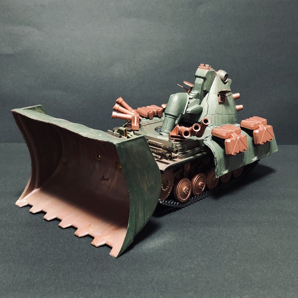 「マゼラベースとしての武装は25ミリ機銃が2門だけと貧弱であるが、友軍のMS部隊支援を目的にスモークディスチャージャーが6器、またマゼラトップの帰還を円滑に支援すべく分離後の生存率を高めるためのリアクティブアーマーが装備されている」