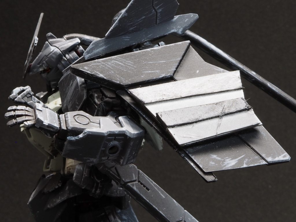 本機はウェザリングのみならず、パーツの一部を故意に損傷させるという表現を取り入れています。頭部アンテナや左手の小指、左腕部アーマーなどをデザインナイフで破損させています。また左肩部には甲冑をモチーフとしたアーマーを装備させています。