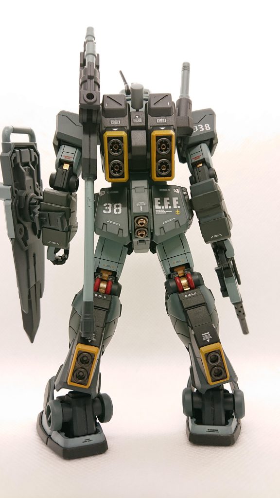 後方より、今回は間接部をゴールドにしました。あとは足間接のパイプをエナメルの赤で塗り分け。バーニアにビーズを入れてディテールアップしました。この機体は切り込み隊長的なポジションで、他の機体よりも先行するだろうと、デカールに関しては前面よりも後方からの視認性を考えて張り付けています。