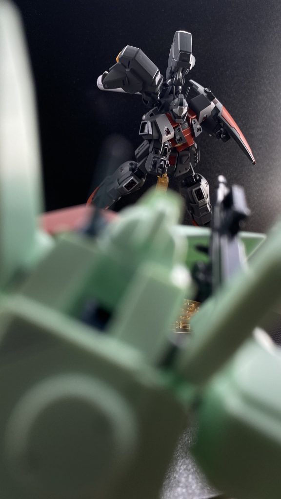 スロットルを開き、フットペダルを踏み込み急上昇する。しかし、アランの目に飛び込んで来たのは、「セルマっ?なんでっ!」 ライフルを構え急降下するジェガンの姿。どこに行った。凄まじいGに耐えながらセルマ機とすれ違うように、互いに急制動。その動きを止めてしまう。「動きを止めるんじゃない、敵を見失った時は物陰に身を隠すんだ」 声、それと同時にレーダーに反応。上。それも上から来たセルマ機よりも。ジェガンを上回る出力を持つあのジムは、その圧倒的な推力を持って、残骸を抜けた瞬間に上昇していたのだ。そして急降下。 真っ直ぐ、動きを止めてしまった2機のジェガンに突撃するジム。斉射されるライフルは、セルマ機を庇うように構えるシールドを、見る間に「赤く」染めていく。「セルマっ、オレのシールドを隠れ蓑に回り込んで」 セルマの返事も待たずに、パージしたシールドをジムの視界をふさぐように蹴り出す。残骸の陰に入るセルマ機を横目に、いま蹴り出したシールドを追うように、ジムに肉迫する。 しかし、そのシールドがぶつかる瞬間を狙った射撃ははずれ、ジムに払われたシールドの陰にアランが見たものは、自機のコクピットに突きつけられたライフルの銃口、そして、同じ様にコクピットにサーベルを突きつけられたセルマ機の姿だ。「セルマ機、アラン機、撃墜だ」 教官の声がインカムから聞こえる。「二人共、良い動きだった、でも、最後の方はいまいちだったかな。シールドを隠れ蓑にアランも一旦隠れて、時間差で挟撃するべきだったな。機動力のある相手は、断続的な攻撃で動きを止めるよう教えたろう。…よし、今回の戦闘訓練は終わり、二人共、お疲れ様。艦に戻ろうか」 そう言う教官機のジムに追従、その背を見ながらアランとセルマ、二人のMS訓練生は声を揃えて言う。「ありがとうございます。ウラキ教官」