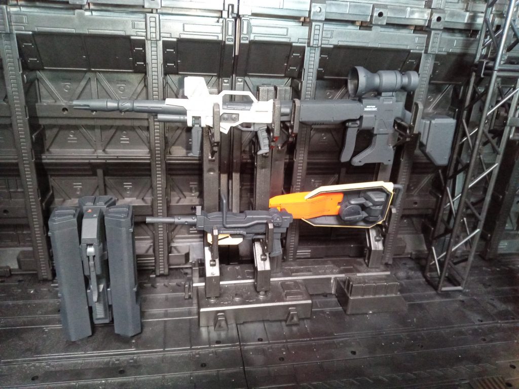 武器ラックにイロイロ。ビームライフル系2丁も付属。スナイパーライフルに、陸Gのビームライフル。ミサイルランチャー。武器ラックに収まりがいいとテンション上がる。