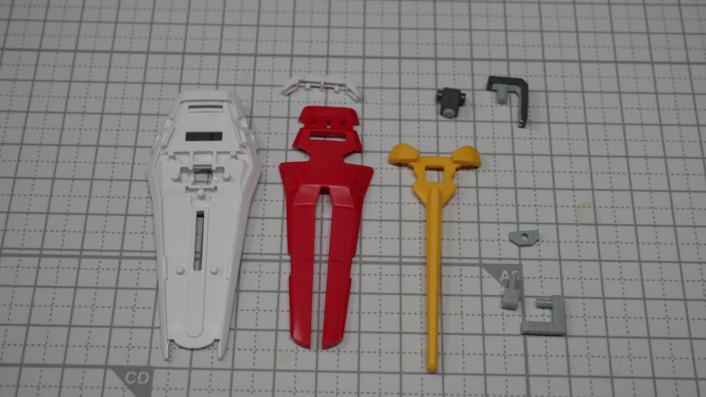 シールド。白い基部と腕部接続の灰色パーツはHGCE、その他はEG。グリップ可動ギミックのために、白いパーツと黄色いパーツは干渉する部分を削り、自作パーツが赤いパーツ裏側の2つのレーンに沿ってスライドできるように調整しました。腕部とシールドの接続パーツは磁石を仕込み、本来シールド接続に使う軸をなくして違和感がないようにしました。わざまえ！