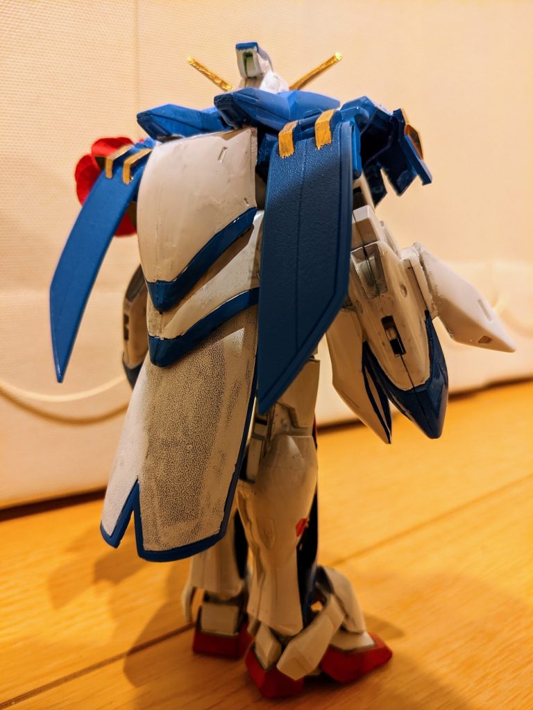 前腕の後ろ袖は１／１００ゼロカスタムの腕アーマーから、突起を抜いたものを使用。背面はオリジナル感を出しつつローズだったっぽさも出したかったので、腰背面にローズのシールドサイド部分を、肩はダブルオーをベースに、肩全面にガンダムローズの右肩を半分ずつ、肩背面にシールド前後部分をそれぞれ接続しました。（これが発色しづらいパーツで、白がムラだらけですが、ご容赦ください…）コアランダーは１／１００ゼロカスタムの肩アーマー青い部分を２つつなげただけです。