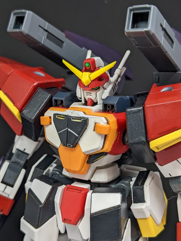 顔のアップ接写すると塗りの甘さと手を加えた部分の荒が目立つ！！！どのW系ガンダムでもそうですが、デザインとして、ひさしが横一直線なんですよね。なので、ほんのわずかひさしを削り、眉間にちっさいパーツを接着。写真のような角度のときに、目がかっこよく見えることを目的にしてみました。というわけで、前回のサタニクスユニットはタイヤによる陸上移動というところから作ったものですが、今回は似たような発想でホバーを用いたミキシングでした。果たして第三段はあるのか。ないのか。ないかもしらんけど