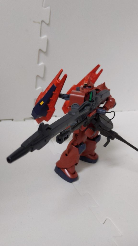 通常のザクⅡと比較して頭部の角の代わりに狙撃用センサーを搭載したりシールドブースターで機動力を増加させたりなどの改良が見られますが最大の特徴は左手に持った実弾ショットガンとメガビームランチャーの複合武器「デュアルショットランチャー」です。重いのでこのように右腕部分で支えて撃ちます。デュアルショットランチャーは機体にコードで接続されており、機体そのものの燃費の悪化や活動時間の制限と引き換えに強力なビーム射撃を可能とします。