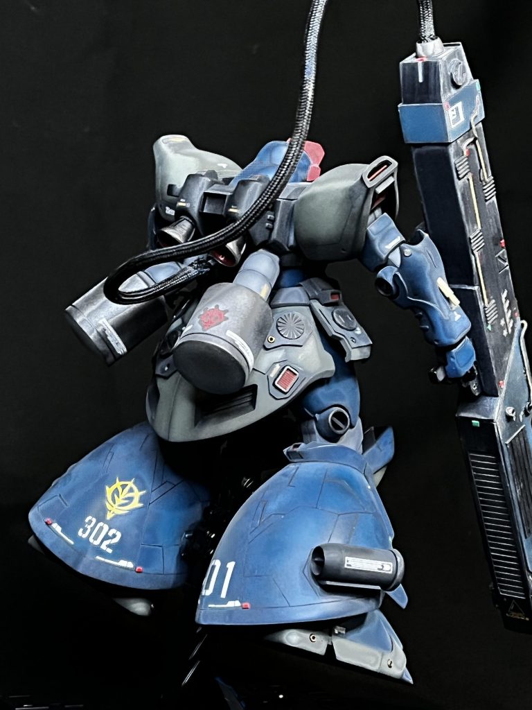 AE社からデータを入手したデラーズ傘下の技術部は独自に小型Iフィールド発生機を開発し、リックドムIIの右脚に装備。バズーカ発射までのタイムラグ中の防御をIフィールドでカバーする。